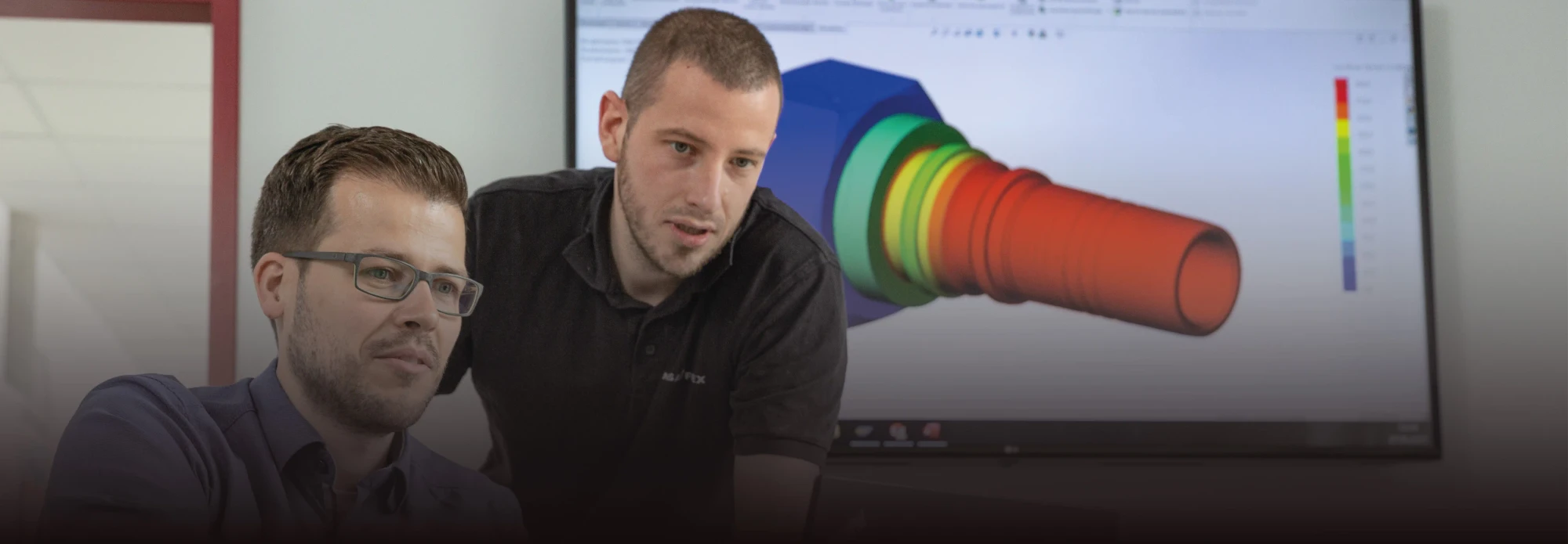 Ingenieros de HANSA-FLEX analizando en pantalla la simulación de un racor de manguera